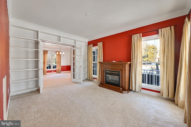 unfurnished living room featuring french doors, ornamental molding, and carpet flooring