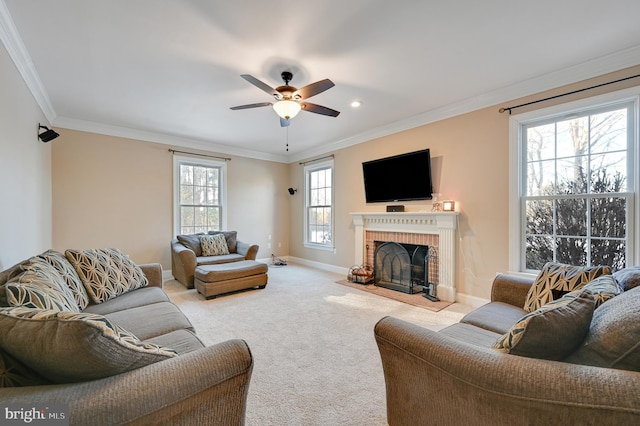 living room featuring crown molding, light colored carpet, ceiling fan, and a fireplace