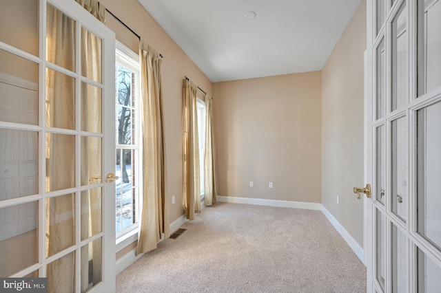 carpeted empty room featuring french doors