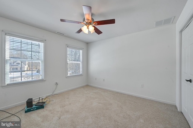 carpeted spare room featuring ceiling fan