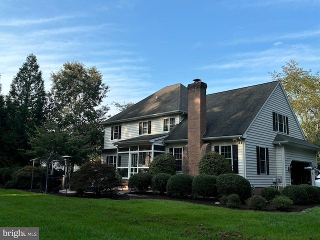 view of front of home with a front yard and a sunroom