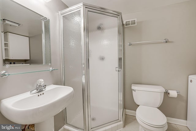 bathroom featuring sink, tile patterned floors, walk in shower, and toilet