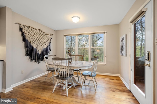 dining space with a wealth of natural light and light hardwood / wood-style flooring