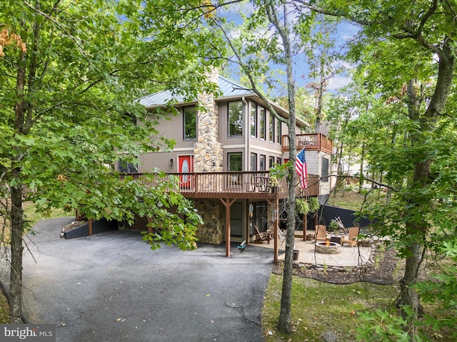 rear view of property with a fire pit and a deck