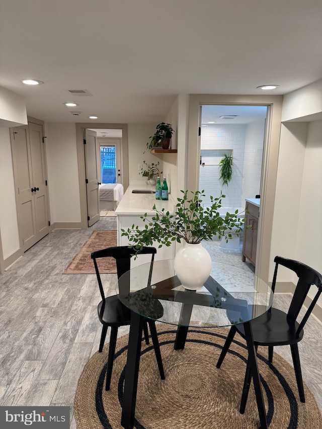 dining room with sink and light hardwood / wood-style flooring