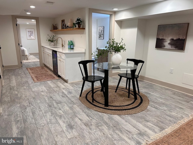 dining area featuring wet bar and light wood-type flooring