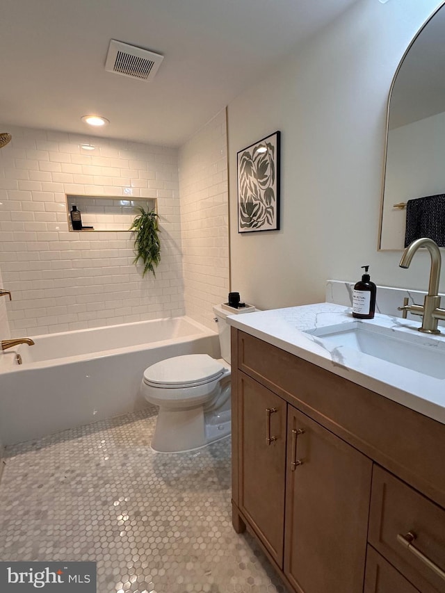 full bathroom with vanity, tiled shower / bath, tile patterned floors, and toilet