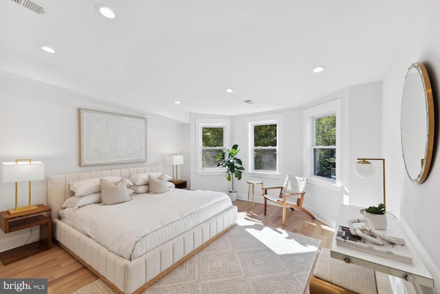 bedroom with vaulted ceiling and light wood-type flooring