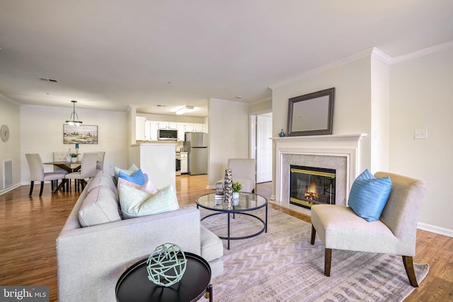 living room with crown molding and light hardwood / wood-style flooring