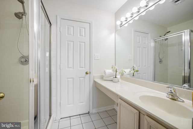 bathroom featuring tile patterned flooring, vanity, and walk in shower