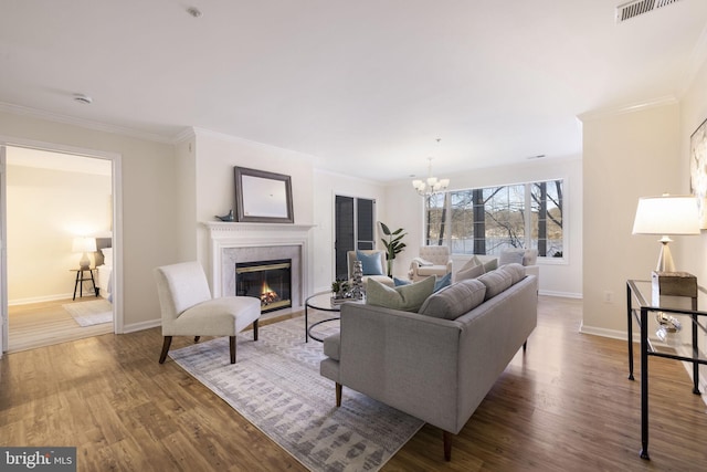 living room featuring an inviting chandelier, hardwood / wood-style flooring, and ornamental molding