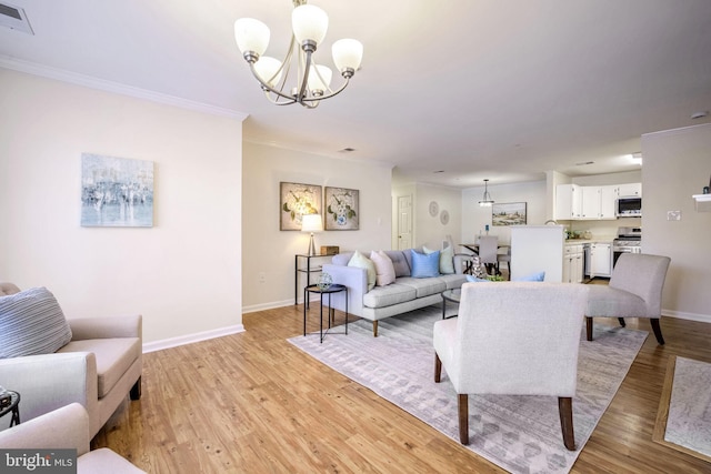 living room with crown molding, an inviting chandelier, and light hardwood / wood-style floors