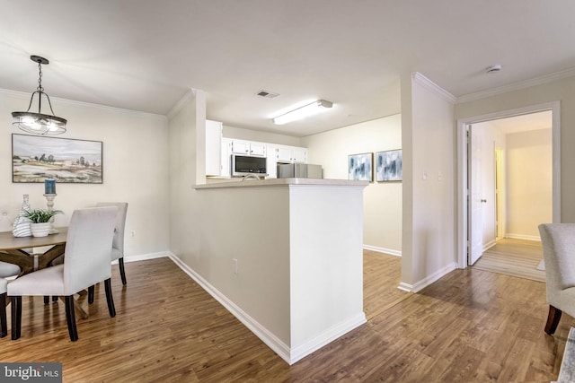 dining space with crown molding and wood-type flooring