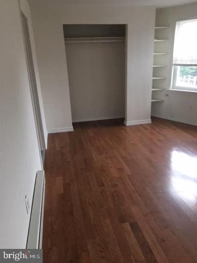 unfurnished bedroom with dark hardwood / wood-style flooring