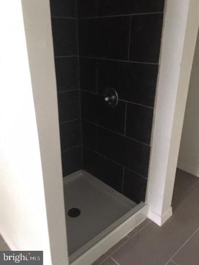 bathroom featuring tile patterned flooring and tiled shower