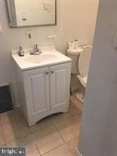 bathroom featuring toilet, tile patterned flooring, and vanity