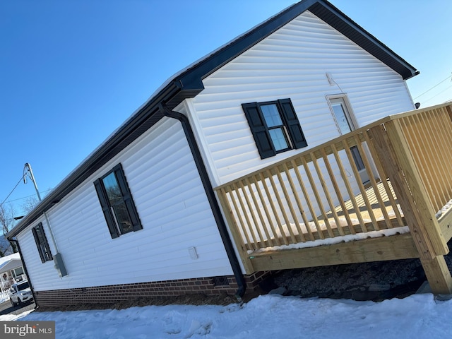 snow covered property with a wooden deck