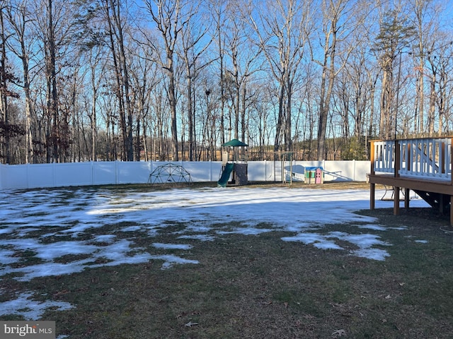 yard covered in snow featuring a playground