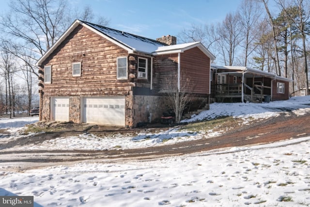 view of snowy exterior featuring a garage