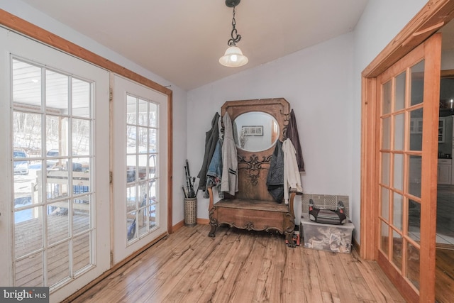 doorway to outside featuring light wood-type flooring, vaulted ceiling, and french doors