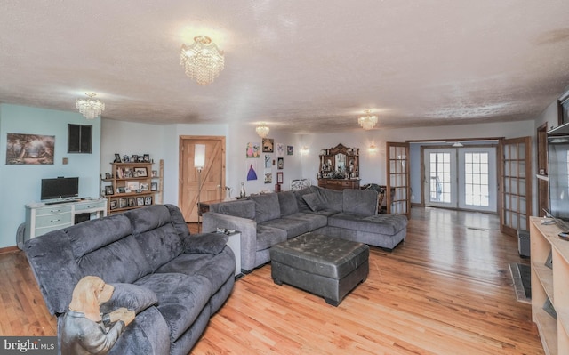 living room featuring a textured ceiling, wood-type flooring, and french doors