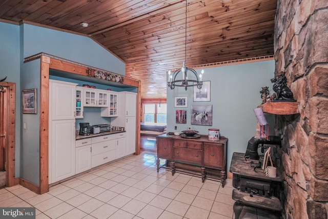 kitchen with an inviting chandelier, white cabinetry, wood ceiling, lofted ceiling, and pendant lighting