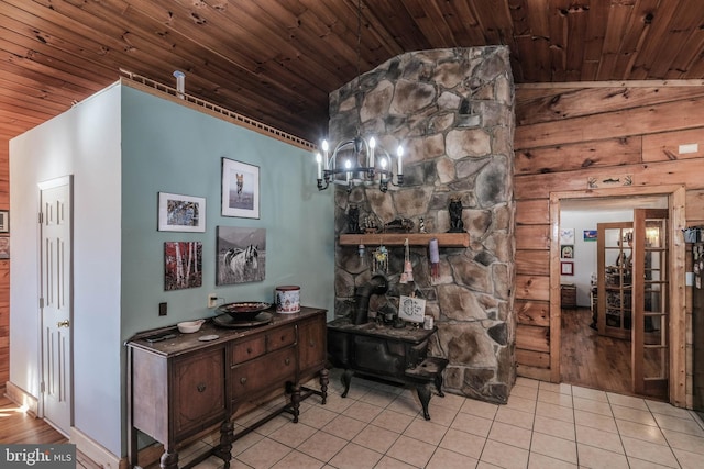 interior details featuring wooden ceiling, a wood stove, and a notable chandelier