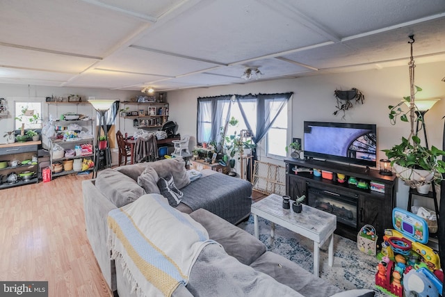 living room with hardwood / wood-style floors, coffered ceiling, and a fireplace