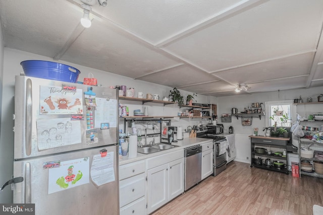 kitchen with white cabinetry, stainless steel appliances, a textured ceiling, light hardwood / wood-style flooring, and sink