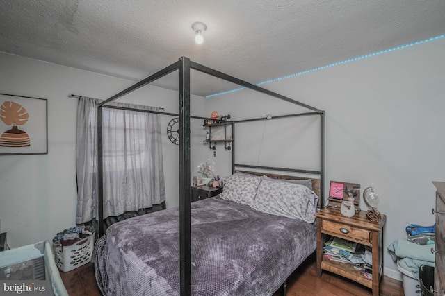 bedroom with a textured ceiling and hardwood / wood-style floors