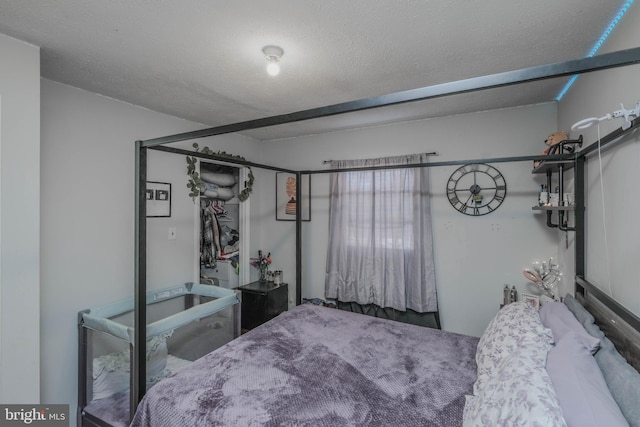 bedroom with a textured ceiling and a closet