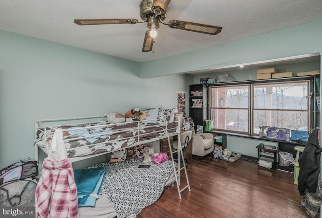 bedroom with ceiling fan, dark wood-type flooring, and a textured ceiling