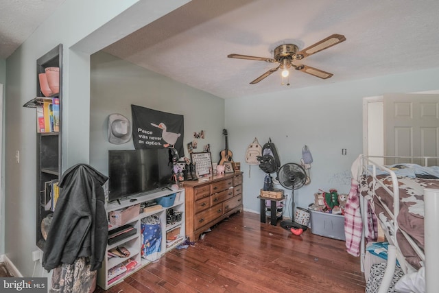 bedroom with ceiling fan, dark wood-type flooring, and a textured ceiling