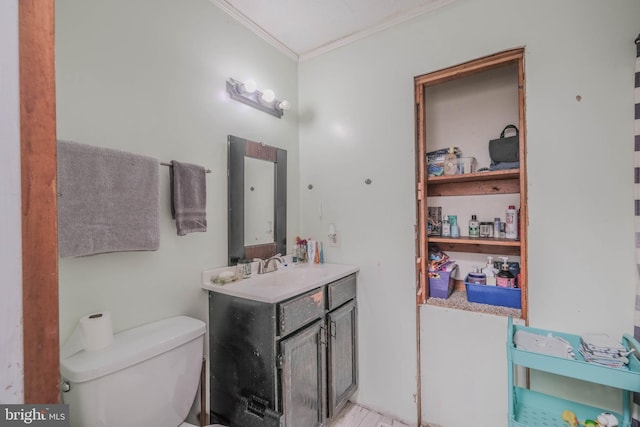 bathroom with toilet, vanity, and ornamental molding