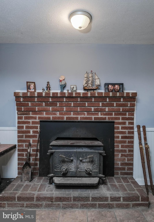 interior details featuring a wood stove and a textured ceiling