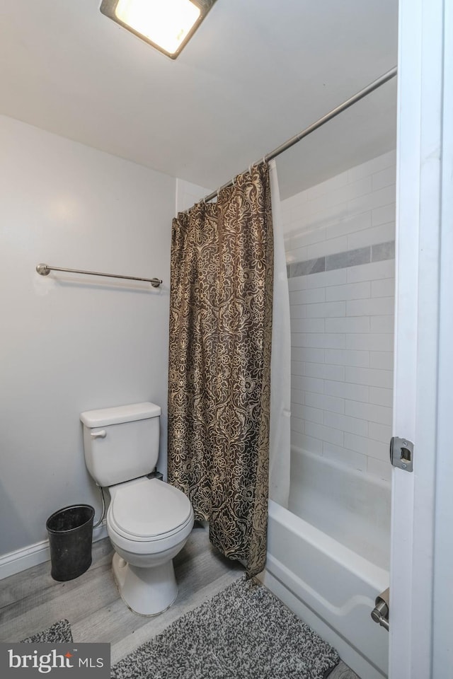 bathroom with hardwood / wood-style flooring, toilet, and shower / tub combo