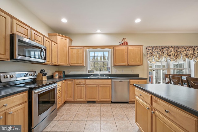 kitchen featuring dark countertops, appliances with stainless steel finishes, a sink, and recessed lighting