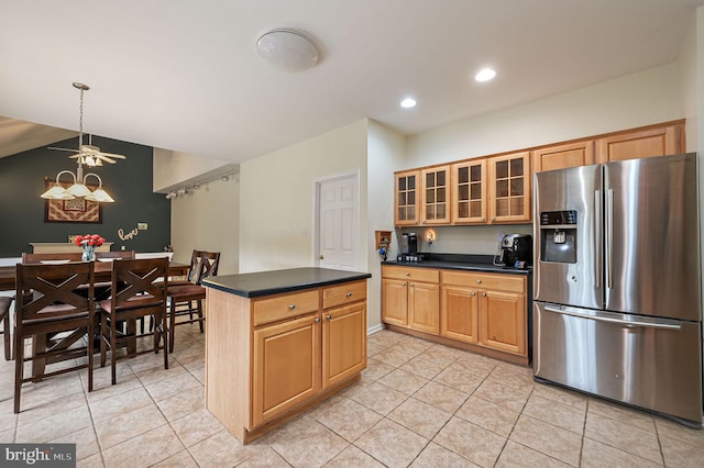 kitchen with light tile patterned floors, stainless steel fridge with ice dispenser, a center island, dark countertops, and glass insert cabinets