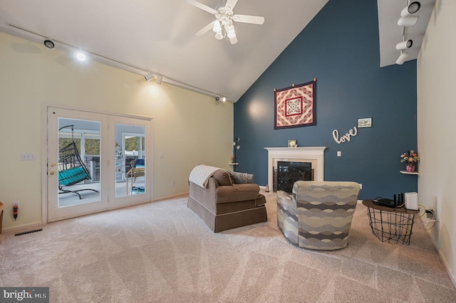 sitting room featuring ceiling fan, a premium fireplace, carpet flooring, high vaulted ceiling, and track lighting