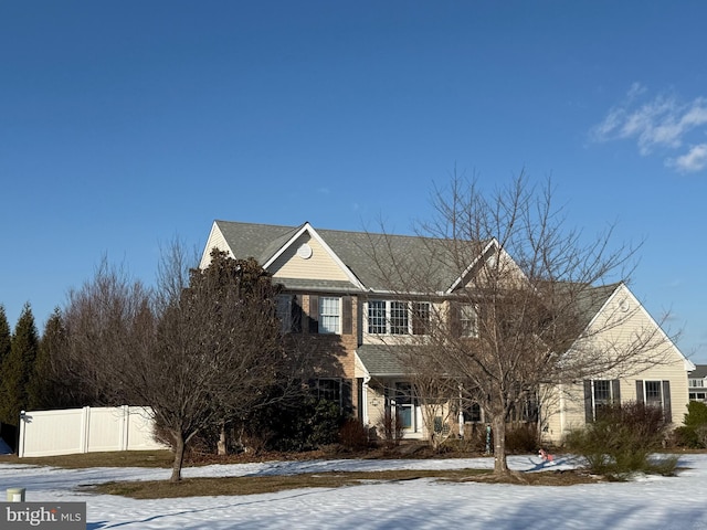 traditional-style house featuring fence