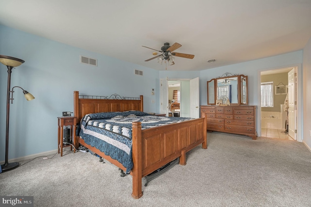 bedroom with light carpet, ensuite bath, visible vents, and a ceiling fan