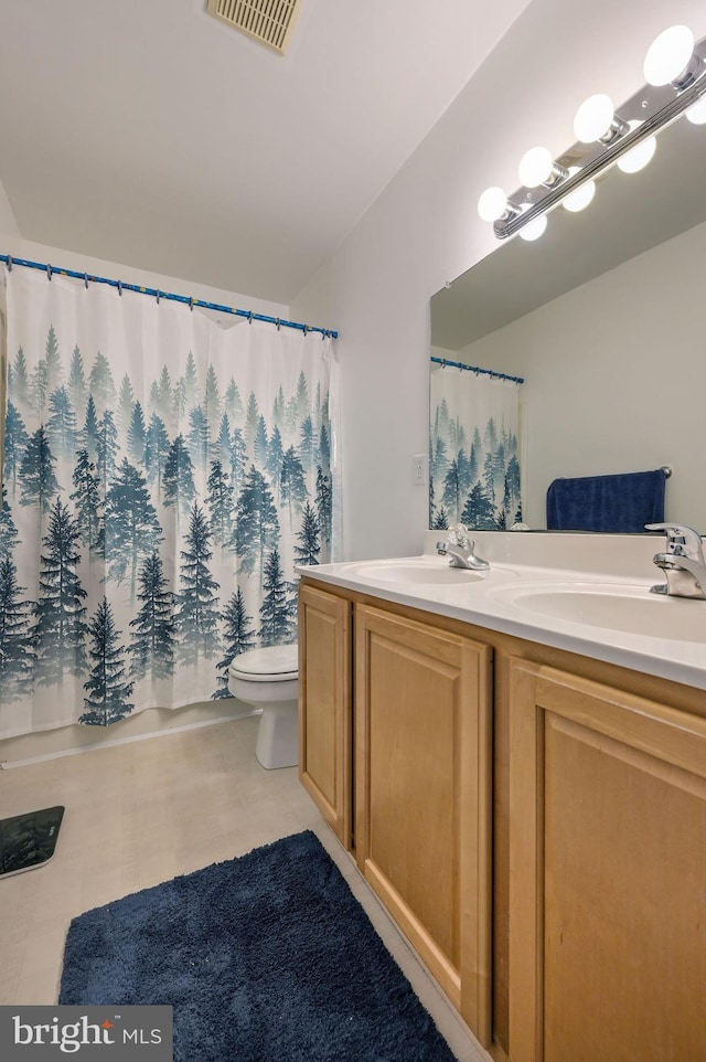 full bathroom featuring visible vents, a sink, toilet, and double vanity