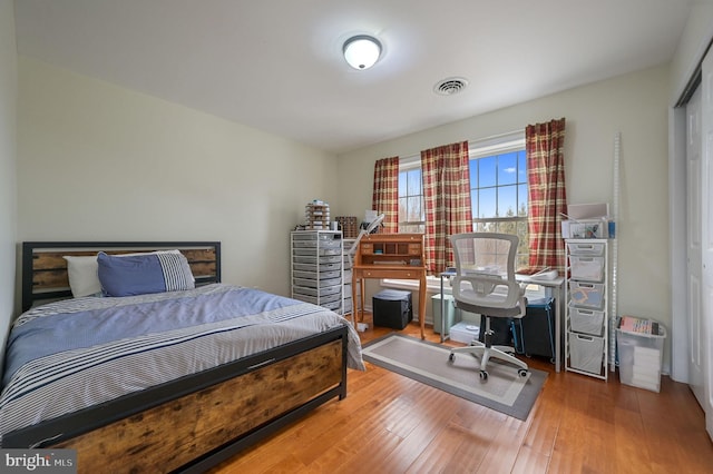 bedroom with wood finished floors and visible vents