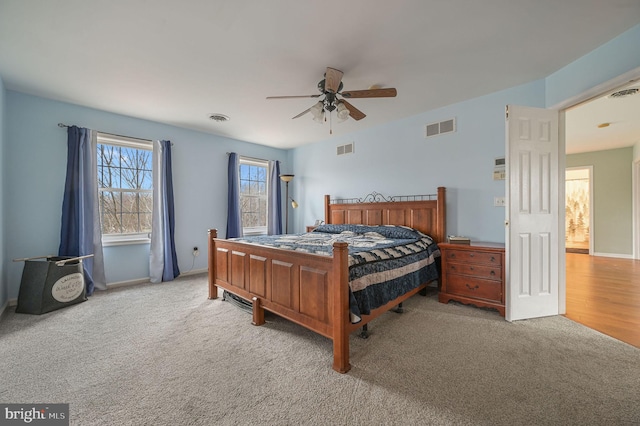 carpeted bedroom with visible vents and a ceiling fan