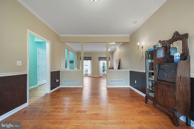 living area featuring visible vents, crown molding, and wood finished floors