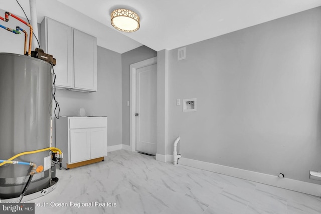 laundry room featuring water heater, cabinets, and washer hookup