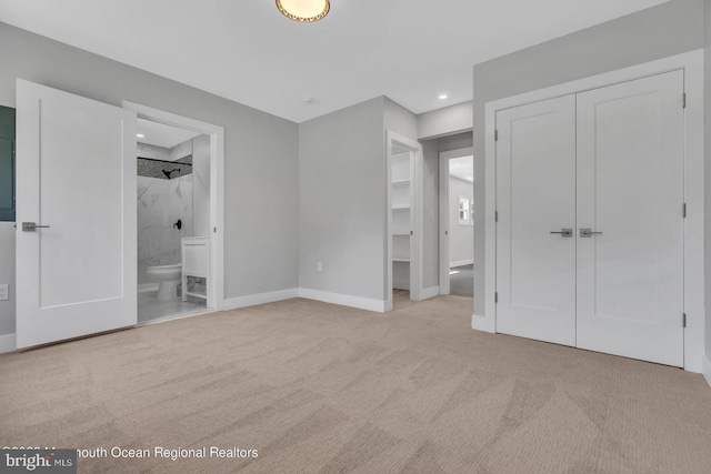 unfurnished bedroom featuring ensuite bath and light carpet