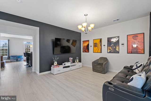 living room featuring an inviting chandelier and light hardwood / wood-style floors