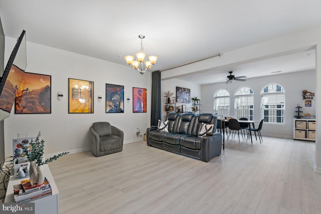 living room with light hardwood / wood-style floors and ceiling fan with notable chandelier