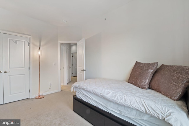 bedroom featuring light colored carpet and a closet